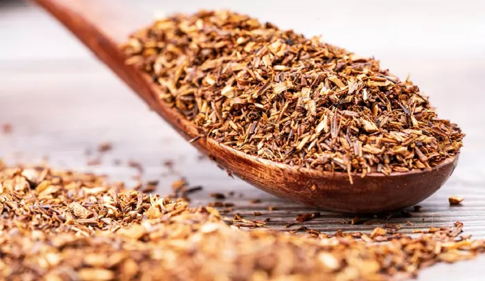 A wooden spoon of loose rooibos tea